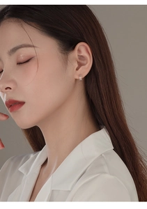 Close-up of minimalist double-layer silver hoop earrings worn by a model