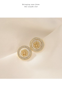 Detailed macro of gold camellia earrings with white petals and pave zircon borders