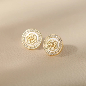 Close-up of golden S925 silver camellia stud earrings with sparkling pavé zircons