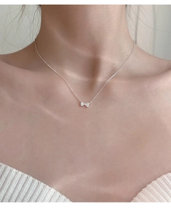 Detail of 925 silver bow necklace featuring pave-set crystals on a dainty cable chain