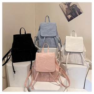 Detailed display of vintage backpacks in black, pink, blue, and white with crinkled texture