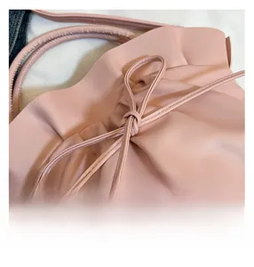 Close-up of the delicate bow and ruched detailing on the pink French cloud bag