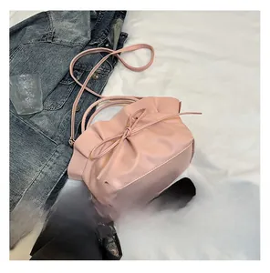 Detailed view of the pink pleated cloud bag featuring a soft leather bow and handle