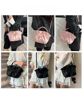 Cloud-shaped pleated drawstring crossbody bag in pink and black shown on a model