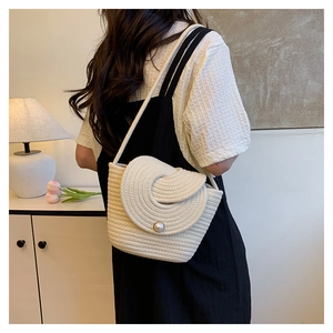 Détail du sac seau en corde crème avec tissage en spirale et boucle en perle élégante