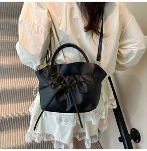 Detail of black cloud bag featuring ruffled edges and a delicate drawstring bow detail