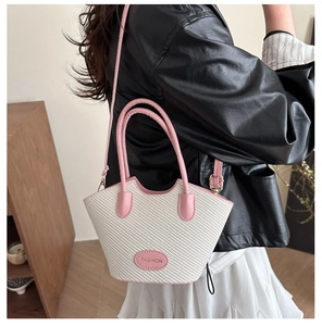 Chic woven handbag in pink and white shown on model for a stylish lifestyle look