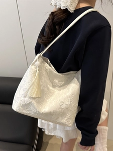 Fashionable white lace tote bag with butterfly embroidery and tassel on model