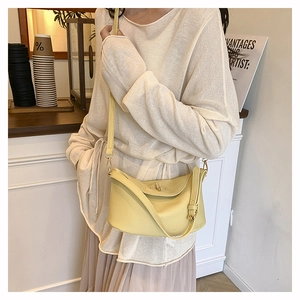 Detailansicht einer gelben Eimertasche aus Leder mit Lychee-Muster, getragen von Model