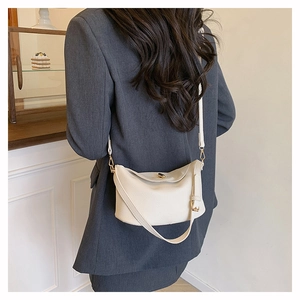 Detailansicht der cremefarbenen Handtasche aus Leder mit feiner Litschimaserung und Goldakzenten