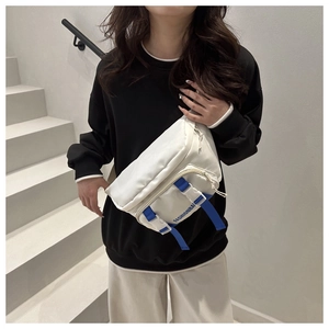 Close-up of white nylon crossbody bag with blue Fashionba buckle strap on model