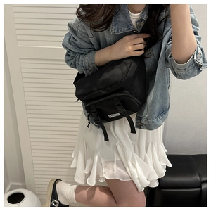 Detail view of black nylon crossbody chest bag with adjustable strap and multiple pockets