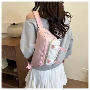Detail view of a pink and white contrast waist bag showing its crossbody strap and side buckle