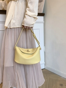 Hellgelbe Hobo-Tasche aus Kieselleder mit goldenen Beschlägen an einem Modell