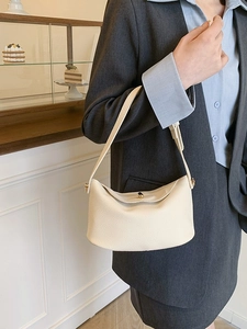 Minimalistische cremeweiße Hobo-Tasche aus Leder mit Metallverschluss am Modell