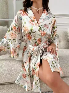 Detail of floral satin robe with pink flowers and wide sleeves on a soft sofa