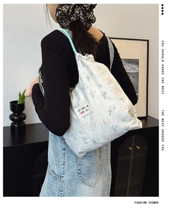 Detail of floral rabbit print nylon tote bag with colorful side label on shoulder strap