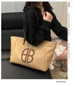 Detail der weichen beigen Ledertasche mit braunem B-Patch und Schultergurten