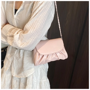 Close-up of light pink pleated cloud bag with silver chain strap and soft PU texture