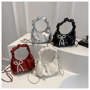 Detail of hobo cloud bags with pleated handles, pearl bows and metal heart charms