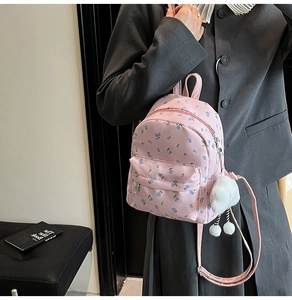 Détail d'un mini sac à dos rose à fleurs avec un porte-clés nuage en peluche mignon