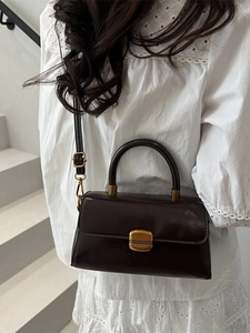 Elegant dark brown oil wax leather crossbody bag with top handle and gold metal buckle