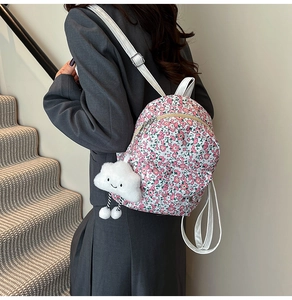 Détail du mini sac à dos floral avec breloque nuage blanc et motifs fleuris