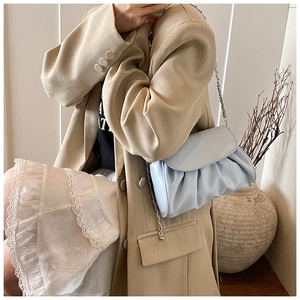 Detail of light blue pleated cloud bag with silver chain strap on a blazer outfit