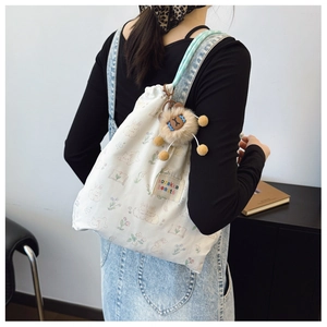 Détail du sac en toile blanche avec imprimé lapin fleuri et breloque lion en peluche