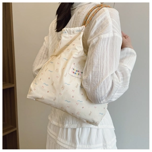 Close-up of cute cartoon canvas tote bag with colorful bear prints and drawstring strap