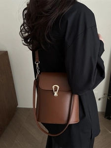 Brown leather bucket bag with gold metal hardware shown on model for daily outfit style