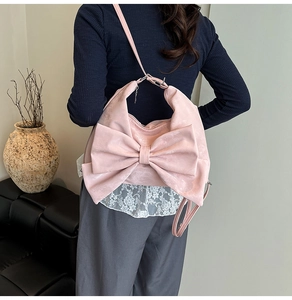 Rear view of a sweet pink bow-shaped shoulder bag showing its size and drape on body