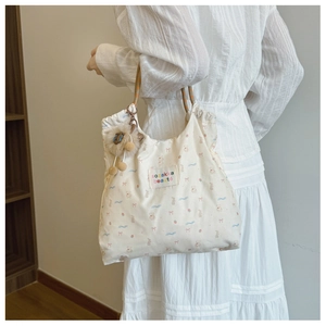 Detail of white canvas tote bag with cute bear and strawberry prints and rope handles