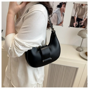 Detail of minimalist black hobo bag showing matte leather texture and gold buckle hardware