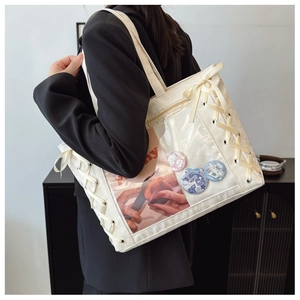 Detail of white canvas tote bag with transparent PVC window and silk ribbon lace-up side