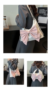 Detail view of cream white convertible bag with a large soft pink bow and adjustable straps