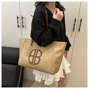 Detail der aprikosenfarbenen XL-Shopper mit braunem B-Logo und Lederstruktur