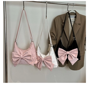 Three elegant crescent hobo bags with large bows in pink, white, and black colors