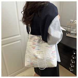 Dettaglio della borsa tote con coulisse e ricami colorati su tessuto jacquard operato