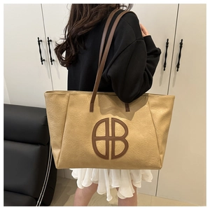 Detail der khakifarbenen Tote-Bag mit weichem Leder und rundem Logo an der Schulter