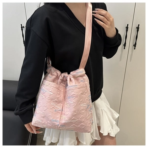 Dettaglio borsa a secchiello rosa trapuntata con ricami arcobaleno e coulisse pratica