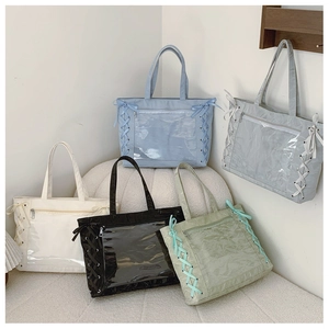 Detail view of large tote bags in five colors with clear windows and ribbon accents