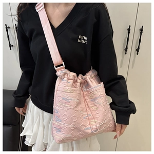Dettaglio della borsa tote rosa trapuntata con cuciture ondulate e tracolla larga