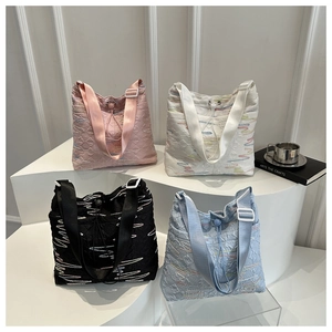Dettaglio borse shopper trapuntate con ricami a onde colorate e chiusura con coulisse