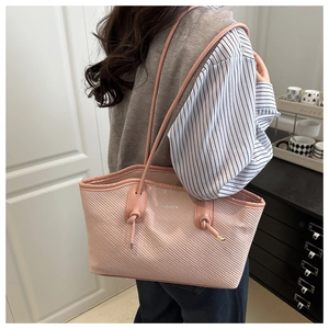 Détail du cabas en tissu rose texturé avec lettrage FASHION et bandoulière à nœuds
