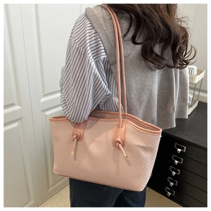 Detail of pink twill fabric tote with knot shoulder strap and metal hardware