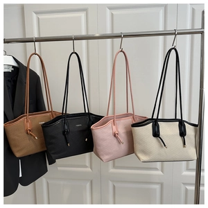 Detail of four textured tote bags in brown, black, white, and pink with knot handle details