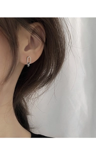 Detail view of silver geometric oval chain earrings on model with polished finish
