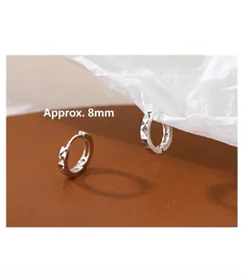 Macro detail of geometric rhombus cut S925 silver hoop earrings measuring 8mm in diameter