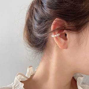 Elegant gold-plated ear cuff with 5 white pearls and a delicate tassel chain on model